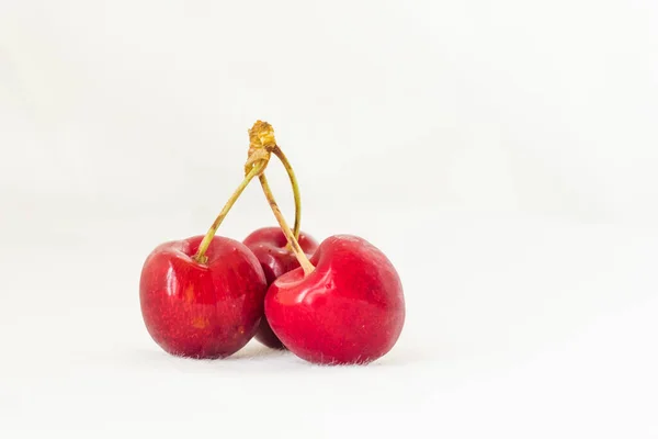 Three Juicy Berries Red Cherry White Fabric Background Few Red — Stockfoto
