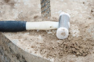 Seismic test on concrete pile. Engineer using the PIT Hand-Held Hammer, the PIT Accelerometer and the Pile Integrity Tester to detect Neck Bulge and Void in the piles