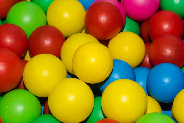 Many colour plastic balls from childrens small town. Background texture of multi-colored plastic balls. Colorful plastic gum balls in kid playroom or playground for childrens holiday party concept