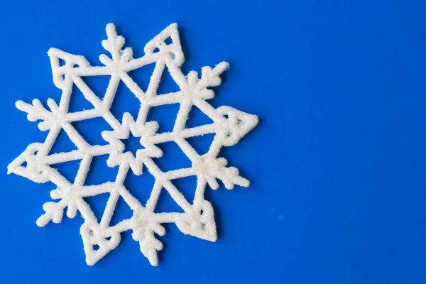 青い紙のカードに1枚の雪片 雪の結晶とヴィンテージクリスマスポストカード 青い背景に美しいクリスマスの白い星 — ストック写真