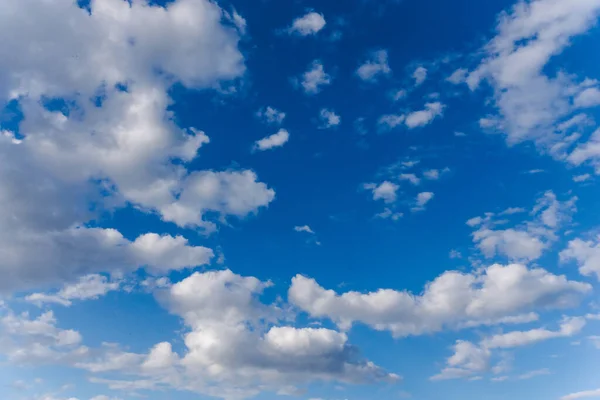 Light cloudy, good weather. White and gray clouds in sun light on the blue sky perfect for the background. Curly clouds on a sunny day.