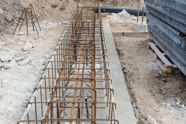 Metal takviyeli monolitik bir temel. Takviye inşaat ağı. Yeni inşaat inşaatı tamamlandıktan sonra beton yığını. Monolitik çalışmalar için bir inşaat aracı.