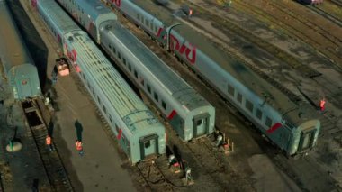 MOSCOW, OCT. 31, 2021: Demiryolu yolcu trenlerinin, yolcu vagonlarının, bakım altında lokomotifin, demiryolu deposunda işçilerin hava görüntüleri. Demiryolu deposu atölyesi, raylar, altyapı. 