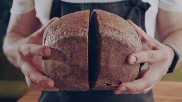 Vers mooi rond brood. Baker toont vers gebakken rond donker brood in gesneden. Close-up. — Stockvideo