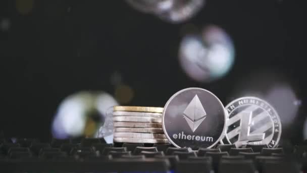 Kryptowährung Ethereum und Litecoin auf schwarzem Hintergrund mit fliegenden Seifenblasen. Virtuelles Geld — Stockvideo