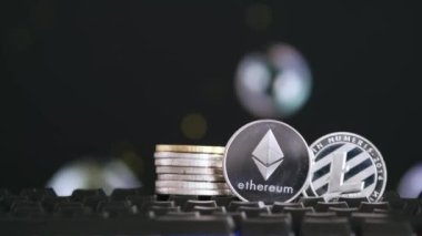 Kripto para birimi Ethereum ve Litecoin uçan sabun köpükleriyle siyah bir zemin üzerinde. Sanal para