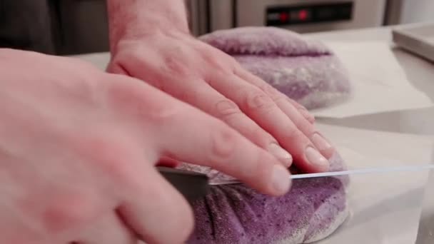 Baker fait une belle coupe sur le pain cru avant la cuisson. Production de pain. — Video