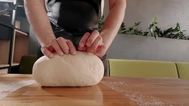 Az ember pék gyúrja a tésztát a sütéshez és a kenyeret a fa asztalon. Lassú mozgás. Házi készítésű sütési folyamat — Stock videók