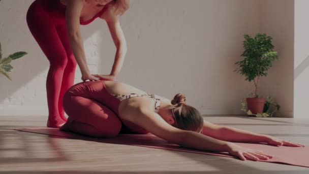 Kadın yoga eğitmeni öğrencinin sırtını germesine yardım eder. Güvenli yoga. Sağlıklı yaşam tarzı kavramı — Stok video
