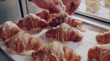 Badem gevrekli kruvasan. Baker taze altın kruvasanları badem taneleriyle süslüyor.