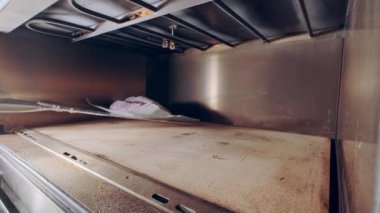 Baker pişirmek için fırına çiğ ekmek koyar. Pişirme üretimi. Çevrim içi tarifler 