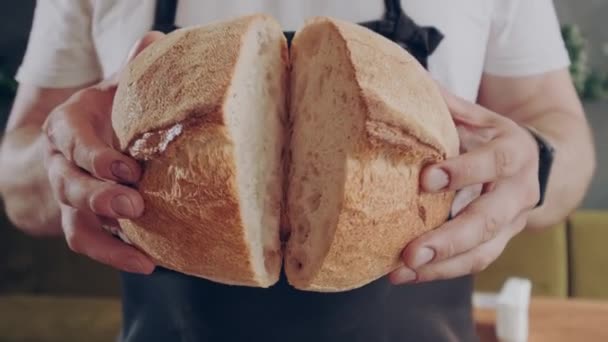 Taze, yuvarlak, taze ekmek. Fırıncı taze pişmiş ekmek gösteriyor. Yakın plan.. — Stok video