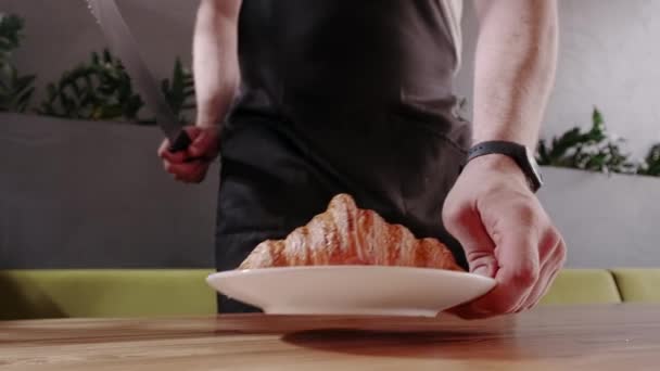 Croissants français classiques. Baker coupe un croissant frais croustillant et montre la texture de la pâte — Video