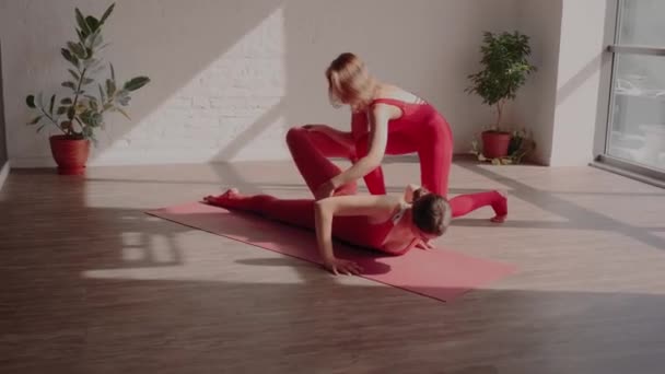 Vrouw yoga trainer helpt haar student om de asana correct uit te voeren. Veilige yoga. Yoga-opleiding — Stockvideo
