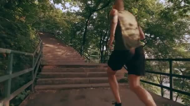 Un joven deportivo sube por las escaleras del parque. Carrera extrema — Vídeo de stock