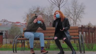 Parktaki bankta oturan erkek ve kadın koruyucu maskelerini çıkarıp iletişim kurmaya başlıyorlar.. 