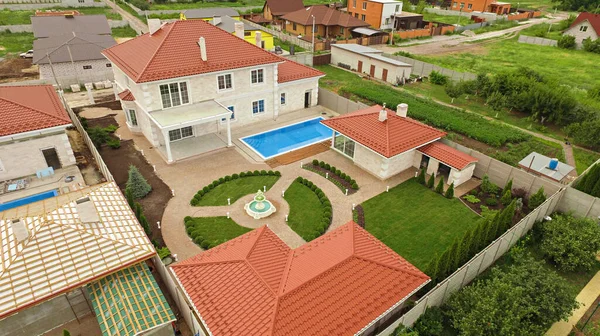 Top view of suburban house with pool, green garden and terrace. Large farm country house. High quality photo