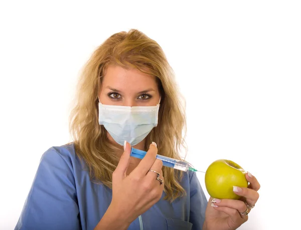 Jonge vrouw arts injecteren groene appel met spuit — Stockfoto