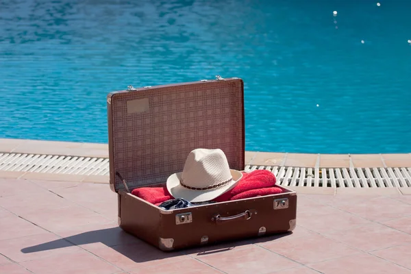 Ročník kufr u bazénu — Stock fotografie