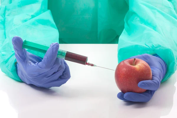 Médico con jeringa y manzana — Foto de Stock