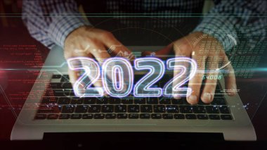 2022 yılı, yeni siber tasarım konsepti. Bilgisayar klavyesinde yazan adam. Fütürist ışık sembolü soyut.