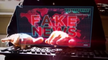 Sahte haber yayını, trolleme, yanlış bilgi, aldatmaca, troll, propaganda, bilgi ve yanlış bilgilendirme ekranda. Evde uzaktan konsept üzerinde çalışmak. Kamera ekran ve klavye yazan adam etrafında hareket eder.