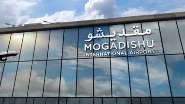 Mogadishu, Somali 'ye inen uçak animasyon yapıyor. Cam havaalanı terminali ve jet uçağının yansımasıyla şehre vardık. Seyahat, iş, turizm ve ulaşım kavramı.
