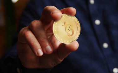 Tezos XTZ açık kaynak, eşdeğer kripto para sembolü elde soyut konsept altın sikke.