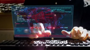 Propaganda, sahte haberler, yanlış bilgilendirme ve manipülasyon ekranda. Evde uzaktan konsept üzerinde çalışmak. Kamera ekran etrafında hareket eder. Klavye yazan adam.