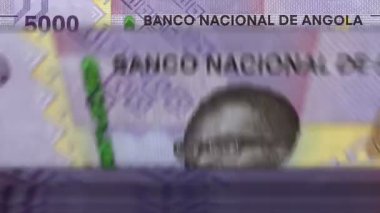 Angolan Kwanza money counting machine with banknotes. Quick AOA currency note down rotation. Business and economy in Angola. Concept loopable and seamless background.