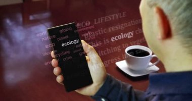 The man is reading the articles on smartphone. Headline news across international media about the Ecology, environment and climate crisis. Abstract concept of news titles on phone in hand.