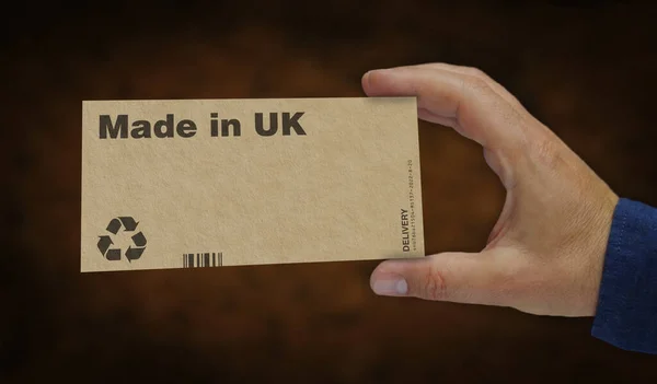 Made in UK box in hand. Manufacturing and delivery. Product factory, import and export. Abstract concept 3d rendering illustration.