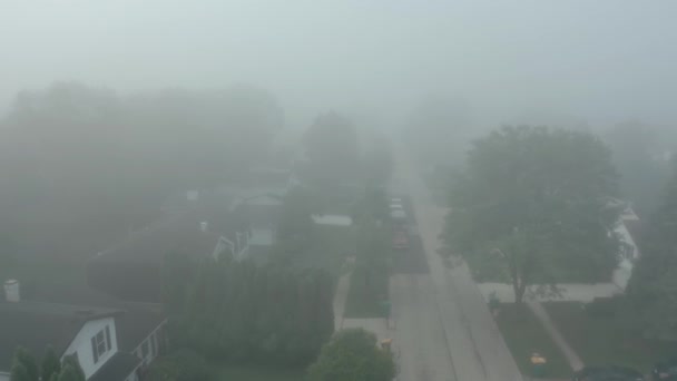 Drone aéreo largo disparado. Bairro residencial coberto por um nevoeiro durante um nascer do sol vibrante. — Vídeo de Stock