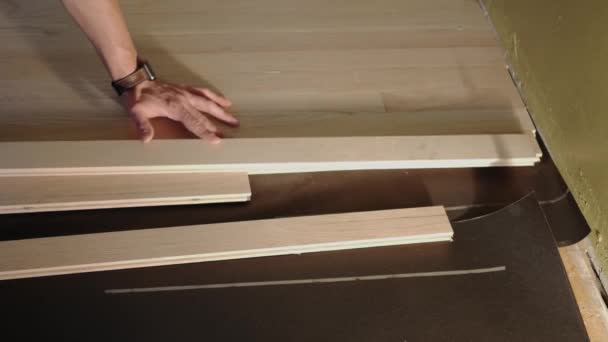 Il lavoratore misura il parquet di legno per installazione — Video Stock