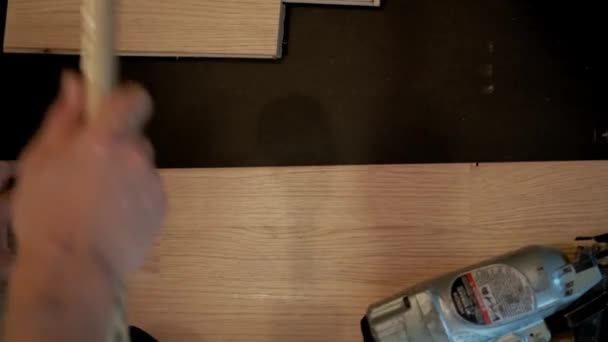 Närbild bild av Man installera parkettgolv plattor över vitt skum basskikt, hamra spikar i med en speciell hammare — Stockvideo