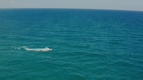 Jet Driving Through Waves 'de çekilen bir çiftin ardından gelen hava aracı. Hava güneşli ve okyanustur. en üstteki görünüm — Stok video