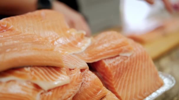 Sluit maar af. Kookt handen voegt peper voor het koken van vis in een professionele houten keukenbord — Stockvideo