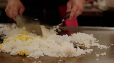 Japon şef hibachi 'de pirinç teppanyaki pişiriyor. Elektrikli ocakta kızartılmış. Yavaş çekim. Yakın çekim.
