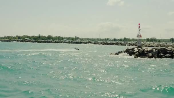 Drone aereo in seguito al colpo di una coppia su un jet che attraversa le onde. Il tempo è soleggiato e oceano. vista laterale — Video Stock