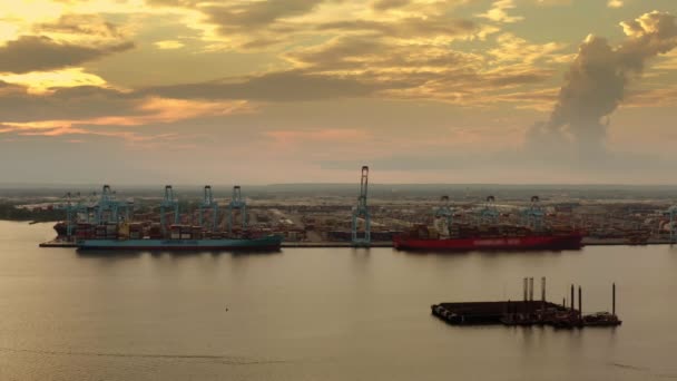装载货物集装箱的货船在港口装卸集装箱时停靠在泊位上的空中景观 — 图库视频影像