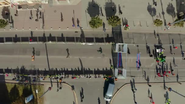 Vista aérea do drone dos corredores, terminando sua marca da linha de partida da maratona nas ruas pacíficas da cidade — Vídeo de Stock