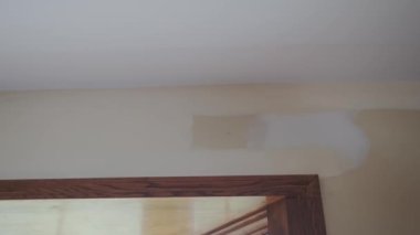 Ressam, duvarı fırçayla boyuyor. Duvarın üstünde kullanışlı resim.