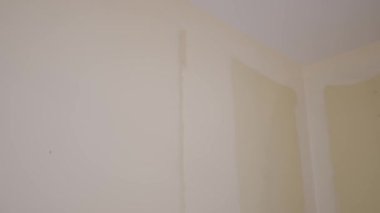 Duvarı silindirle boyayan bir ressam. Duvarın üstünde kullanışlı resim.