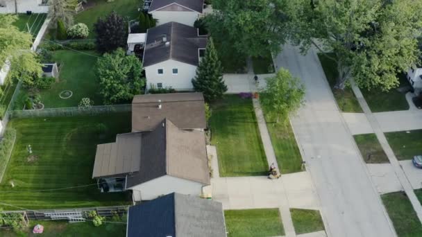 Vue aérienne par drone du tracteur de pelouse fauchant la pelouse par le haut sur la cour — Video