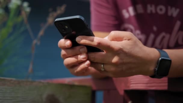 Закрывай. Женщина, использующая iPhone 12 смартфон нажатием пальца, чтение социальных сетей и печатание текста или покупки в Интернете. 20.08.21 Чикаго, США. — стоковое видео