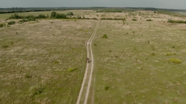 Vista aérea de motoristas de motocicleta que viajam em uma estrada rural. Vista ampla — Vídeo de Stock