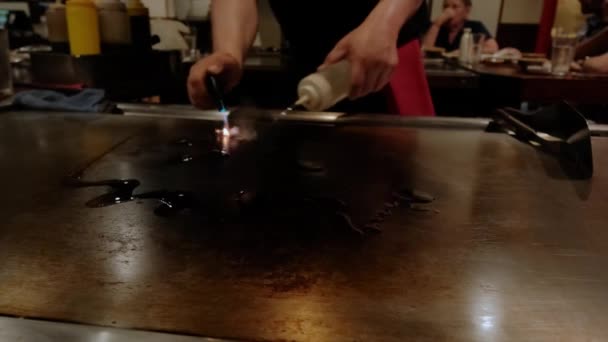 Japanse chef-kok koken teppanyaki op hibachi. Vuur op de kookplaat. Langzame beweging — Stockvideo