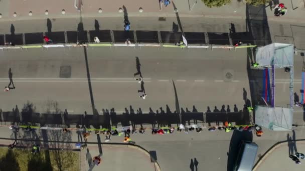 Vista aérea de Runners, terminando su marca desde la línea de salida de la maratón en las tranquilas calles de la ciudad — Vídeos de Stock