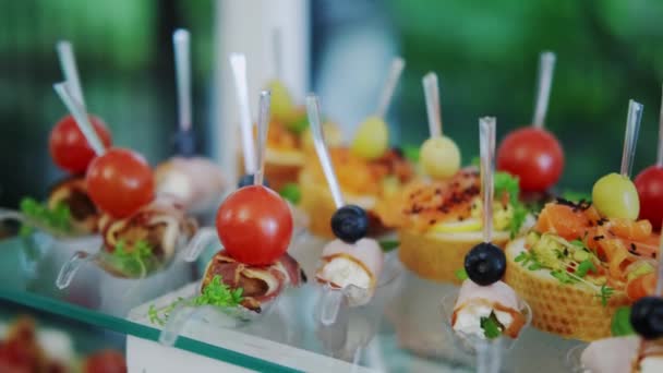 Canapés con salchichas, tomate y sándwiches sobre una mesa. cámara de movimiento — Vídeo de stock