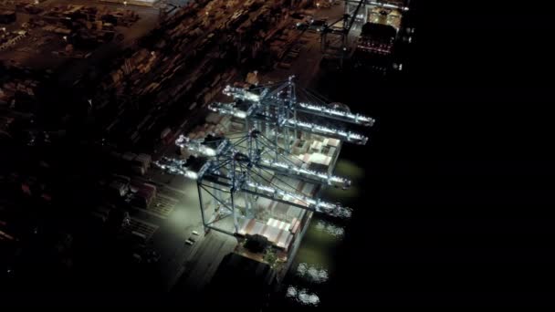 Vista aérea. Navio de carga com contêineres de carga fica em um cais no porto no carregamento e descarga de contêineres à noite.. — Vídeo de Stock